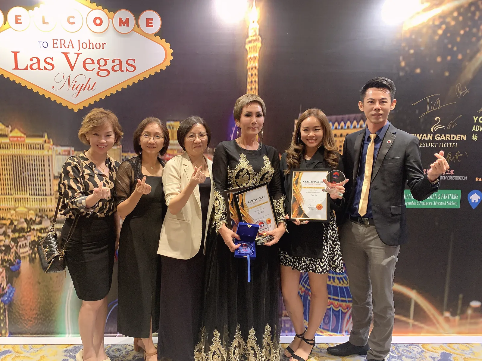 Eve Ang holding her certificate and trophy at the ERA Johor awards night